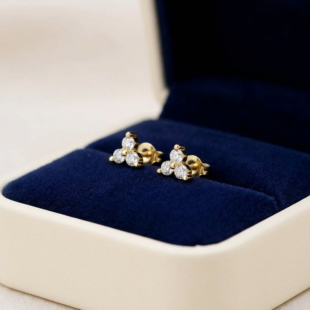 Gold earrings with gemstones in a jewelry box on a neutral background